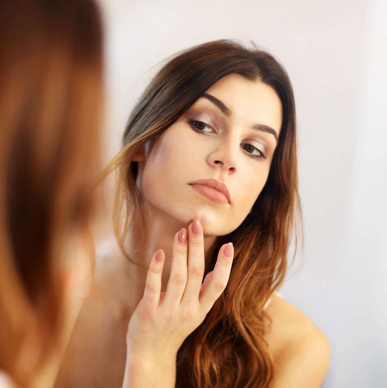 a woman looking at herself in a mirror