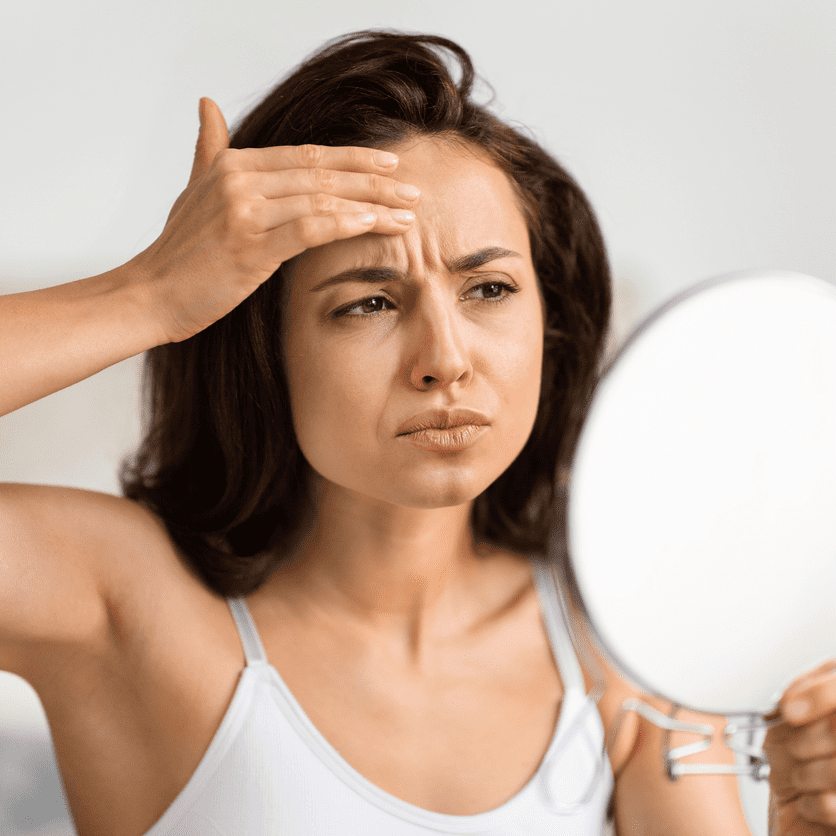 a woman looking at her forehead